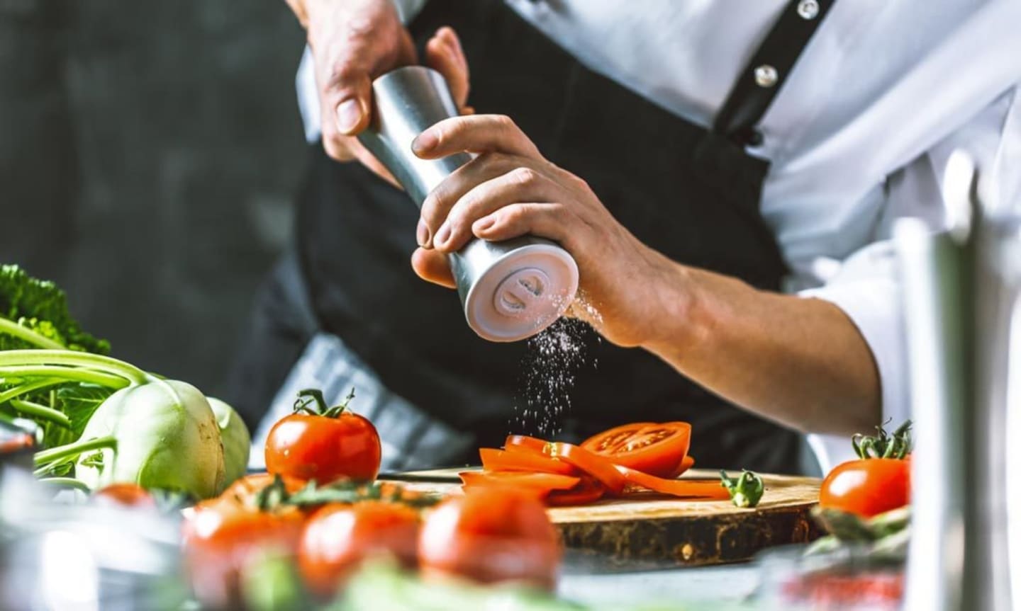 Chef condimentando verduras frescas en Les Chalets Du Lac De Montréjeau en Clarac, Francia