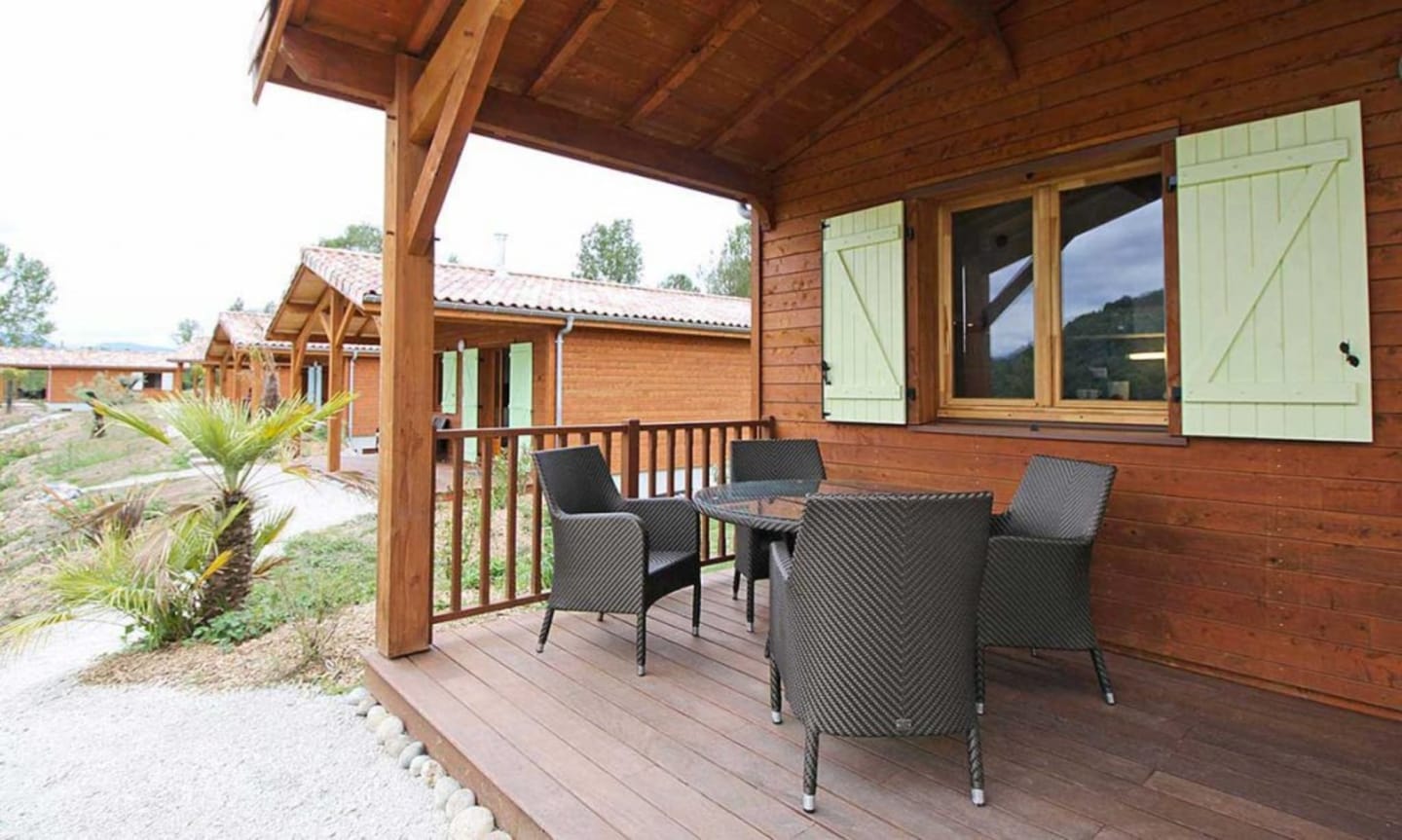 Terrasse en bois avec mobilier de patio offrant une vue panoramique sur les montagnes aux Chalets Du Lac, Clarac