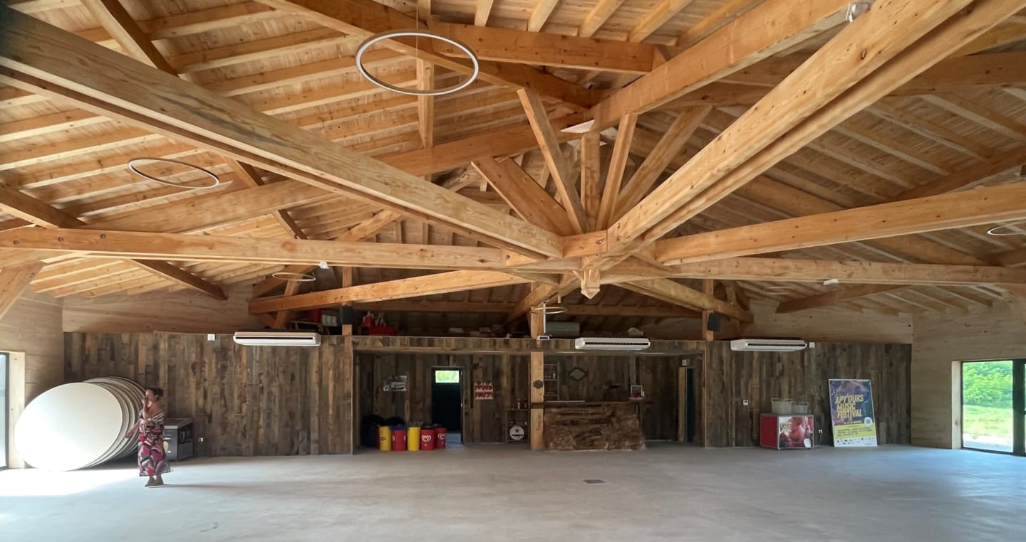 Spacieuse salle d'événements aux poutres en bois des Chalets Du Lac De Montréjeau à Clarac, France avec sol en béton poli