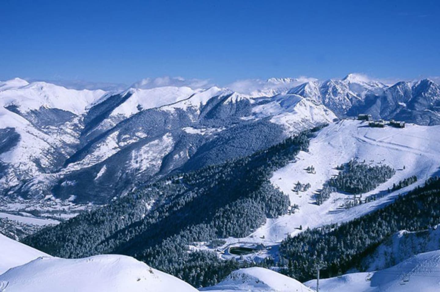 Vallée alpine enneigée avec versants boisés et montagnes près des Chalets Du Lac, Clarac