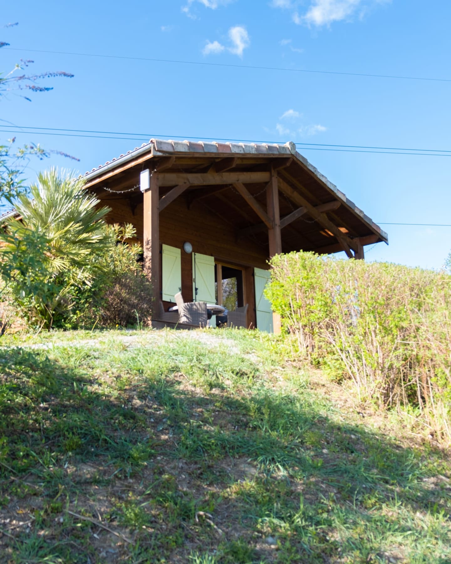 Chalet en bois avec porche couvert entouré de verdure aux Chalets Du Lac, Clarac