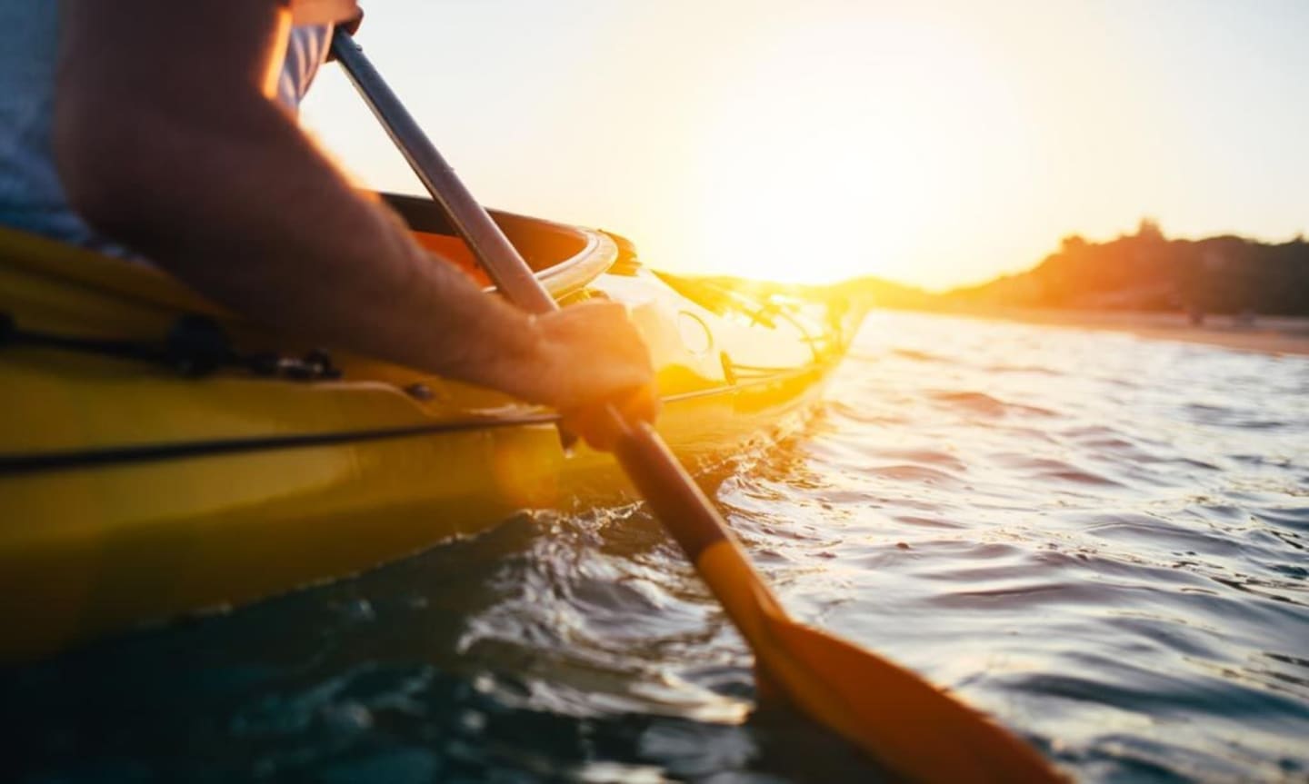 Persona en kayak al atardecer en el lago cerca de Les Chalets Du Lac De Montréjeau en Clarac, Francia