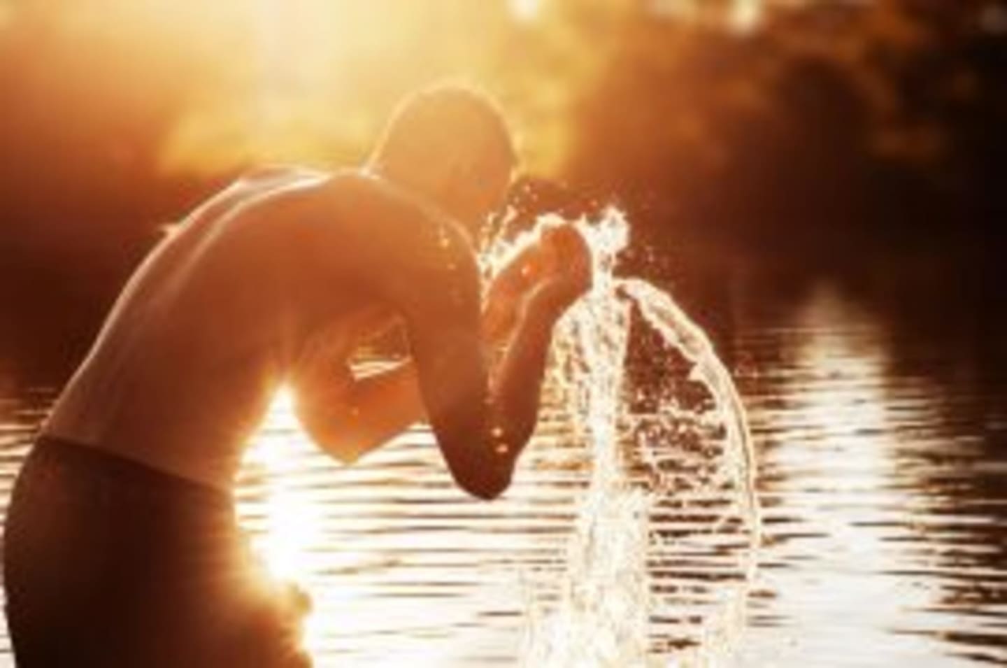 Persona salpicando agua al atardecer junto al lago cerca de Les Chalets Du Lac, Montréjeau