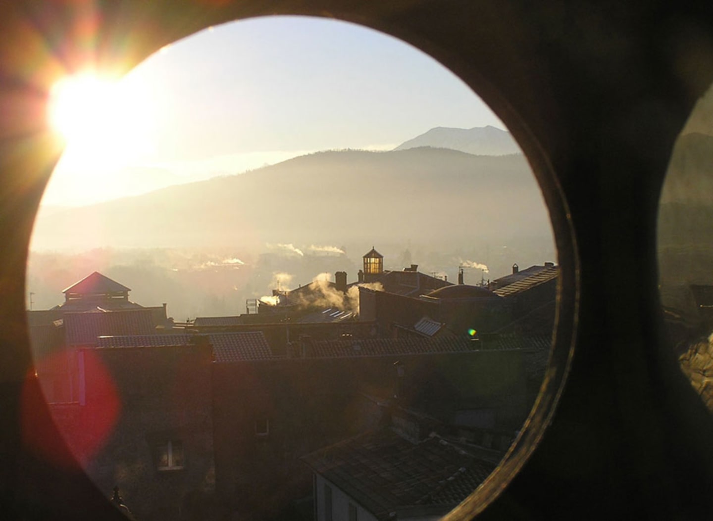 Vista matutina desde Les Chalets Du Lac De Montréjeau mostrando tejados y valle neblinoso en Clarac